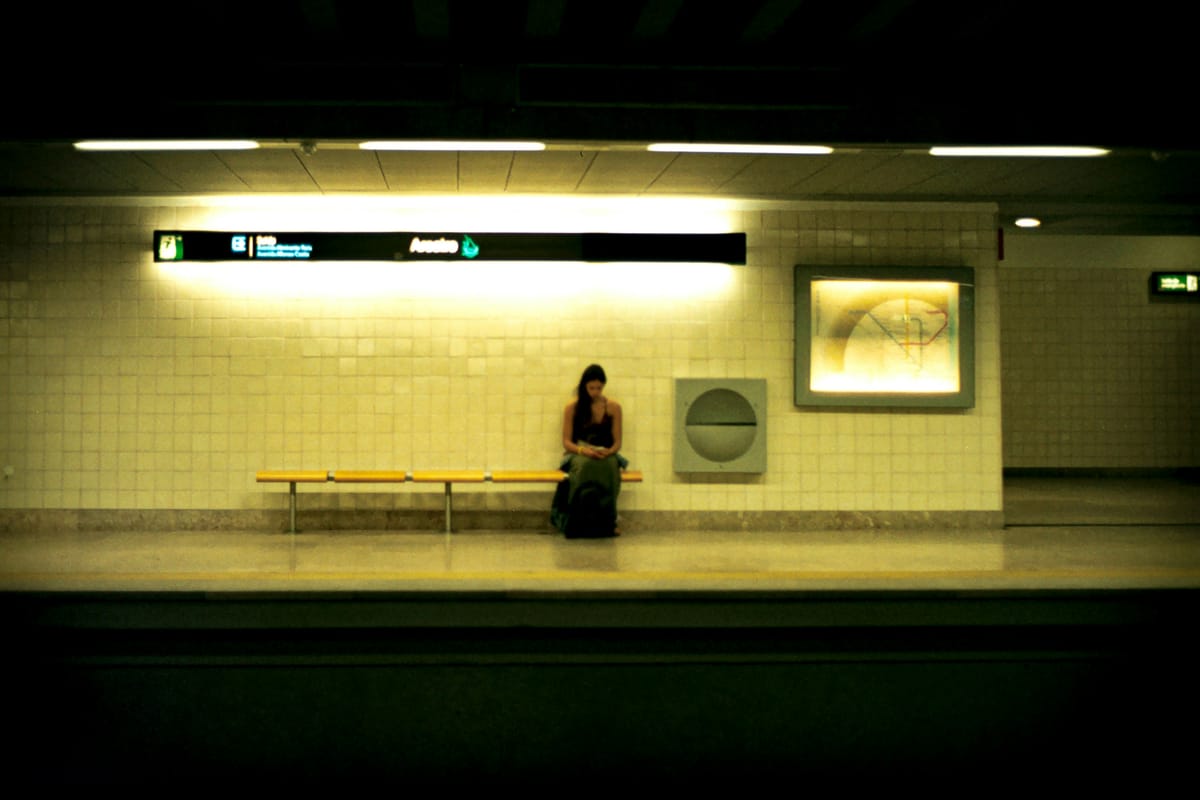 A woman sits in the Lisbon subway